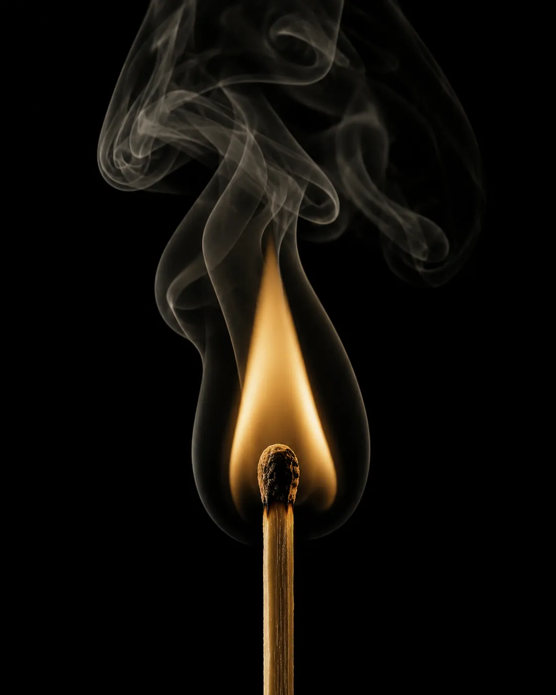 A struck match held vertically against pure black, flame burning at champagne gold with motion-frozen smoke above.